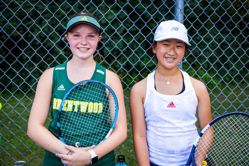Two tennis players smile